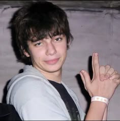 a young man making the peace sign with his hand