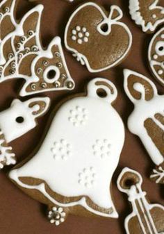 some decorated cookies are laying on a brown table top with white icing and decorations