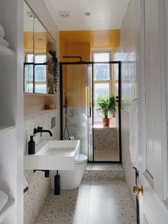 a bathroom with a sink, toilet and shower in it's center wall next to a window