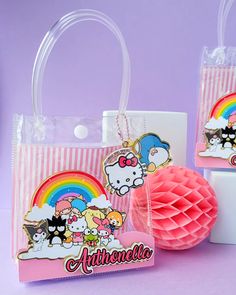 two bags with hello kitty on them sitting next to a tissue ball and cupcake