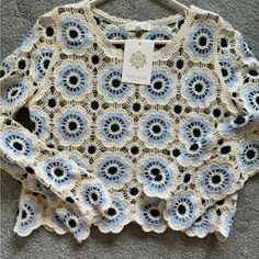 a crocheted sweater with blue and white flowers on it