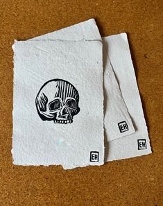 two pieces of paper with an image of a skull on them