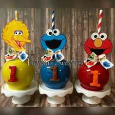 three sesame street birthday candles with the number one on them and two elm street characters