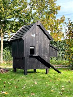 a small wooden structure in the middle of some grass