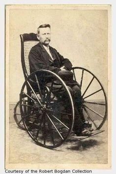 an old photo of a man in a wheel chair