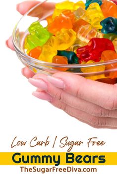 a bowl filled with gummy bears sitting on top of a table next to two hands