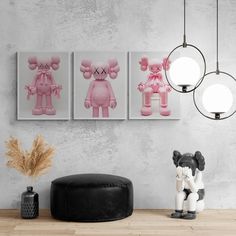 three pink teddy bears are hanging on the wall next to a black ottoman and lamp