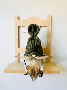 a knitted hat sitting on top of a wooden chair