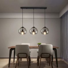 a dining room table with four lights hanging over it