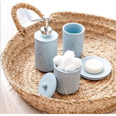 a wicker tray with soap, toothbrush and other items in it on a white table cloth