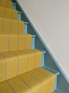 yellow carpeted stairs leading up to a white wall