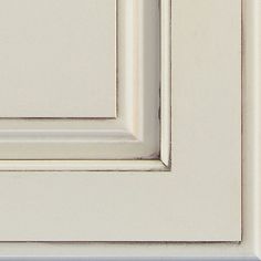 a close up view of the corner of a white cabinet door with no glass on it