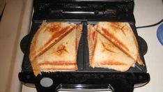 two grilled sandwiches sitting on top of an electric griddle