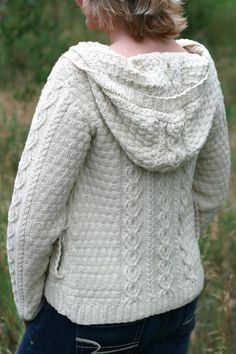 the back of a woman's sweater in white, with an open hood and long sleeves