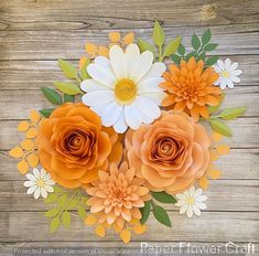 an arrangement of paper flowers sitting on top of a wooden table