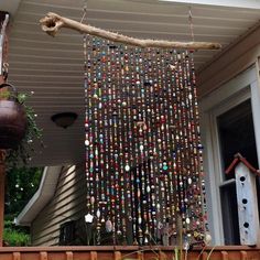 a birdhouse made out of bottle caps is hanging from the side of a house