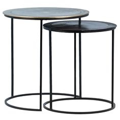 two tables with metal bases and black marble tops, one on each side is round