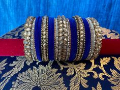 **Tej's Choice** Metal and velvet bangles with kare. These bangles sets are only available in sizes 2.4, 2.6, and 2.8 and are sold as a set for one hand. 2.4 size measures 2.25 inches in diameter2.6 size measures 2.375 inches in diameter2.8 size measures 2.5 inches in diameter Blue Bangles, Traditional Blue Wedding Bangle, Blue Bangle For Festivals And Party, Blue Festive Wedding Bangle, Blue Wedding Bangle For Festive Occasions, Blue Bangle For Weddings And Festivals, Blue Cuff Bracelet For Wedding, Blue Bangle For Party And Festivals, Traditional Blue Bangle For Weddings