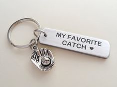 a metal keychain with a baseball glove and ball on it that says, you caught my heart