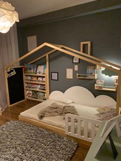 a child's bedroom with a dollhouse bed and bookshelf