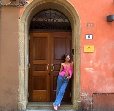 a woman standing in front of a brown door