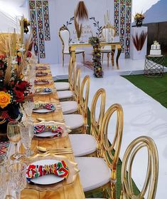 a table set up with gold chairs and place settings