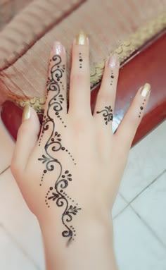 a woman's hand with henna tattoos on it