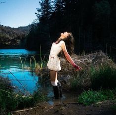 a woman standing in the water with her arms outstretched