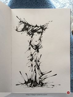 an open book with black and white ink art on the pages, featuring a drawing of a woman's body