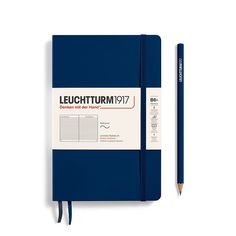 a blue notebook with a pencil next to it on top of a white surface and the words leuchturm77 written in red