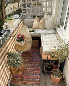 an outdoor patio with potted plants and furniture on the deck, including couches