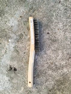 a wooden brush laying on the ground