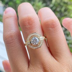 a woman's hand with a ring on it and a diamond in the middle