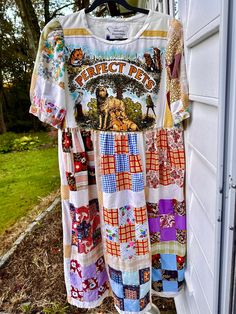 a t - shirt hanging on the side of a garage door with patches of fabric