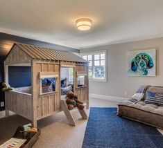 a child's bedroom with a bunk bed, chair and play house in the corner