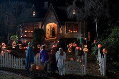 a group of people standing in front of a house decorated for halloween