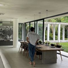 a man standing in front of a dining room table