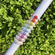 a close up of a white pole with beads on it and smiley rings attached to it