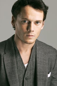 a black and white photo of a man in a suit looking at the camera with an intense look on his face