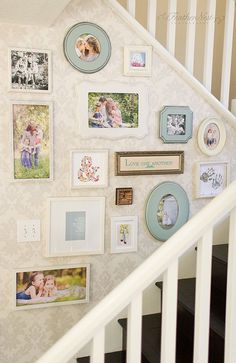 a staircase with pictures and frames on the wall