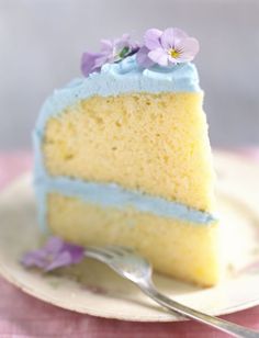 a piece of cake with blue frosting and purple flowers