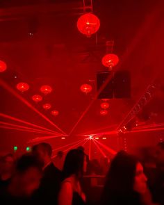 a group of people in a room with red lights