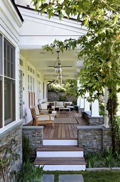 a porch with steps leading up to the front door and sitting area on either side