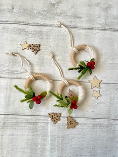 three wreaths made out of wood and rope with christmas decorations around them on a white wooden surface