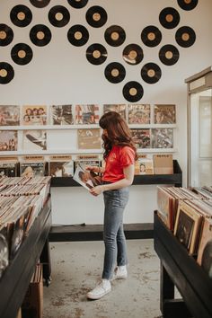 a woman looking at records in a record store