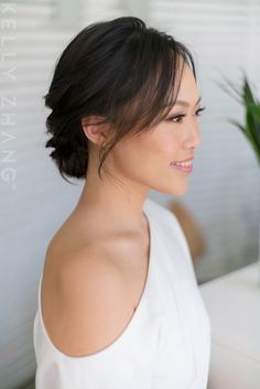 a woman in white dress sitting next to a potted plant and looking off into the distance