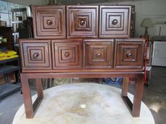 a wooden dresser with many drawers on it