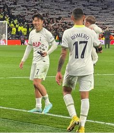 two soccer players are congratulating each other on the field