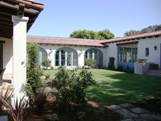 a white house with blue windows and green grass