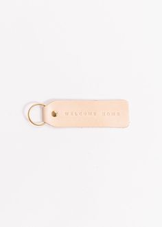 a leather keychain with the words, home is where you are written on it